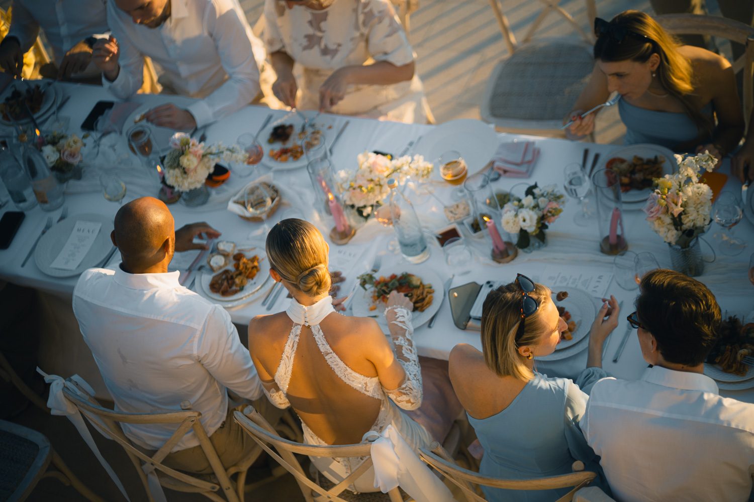 Overhead view of guests around the wedding dinner table.