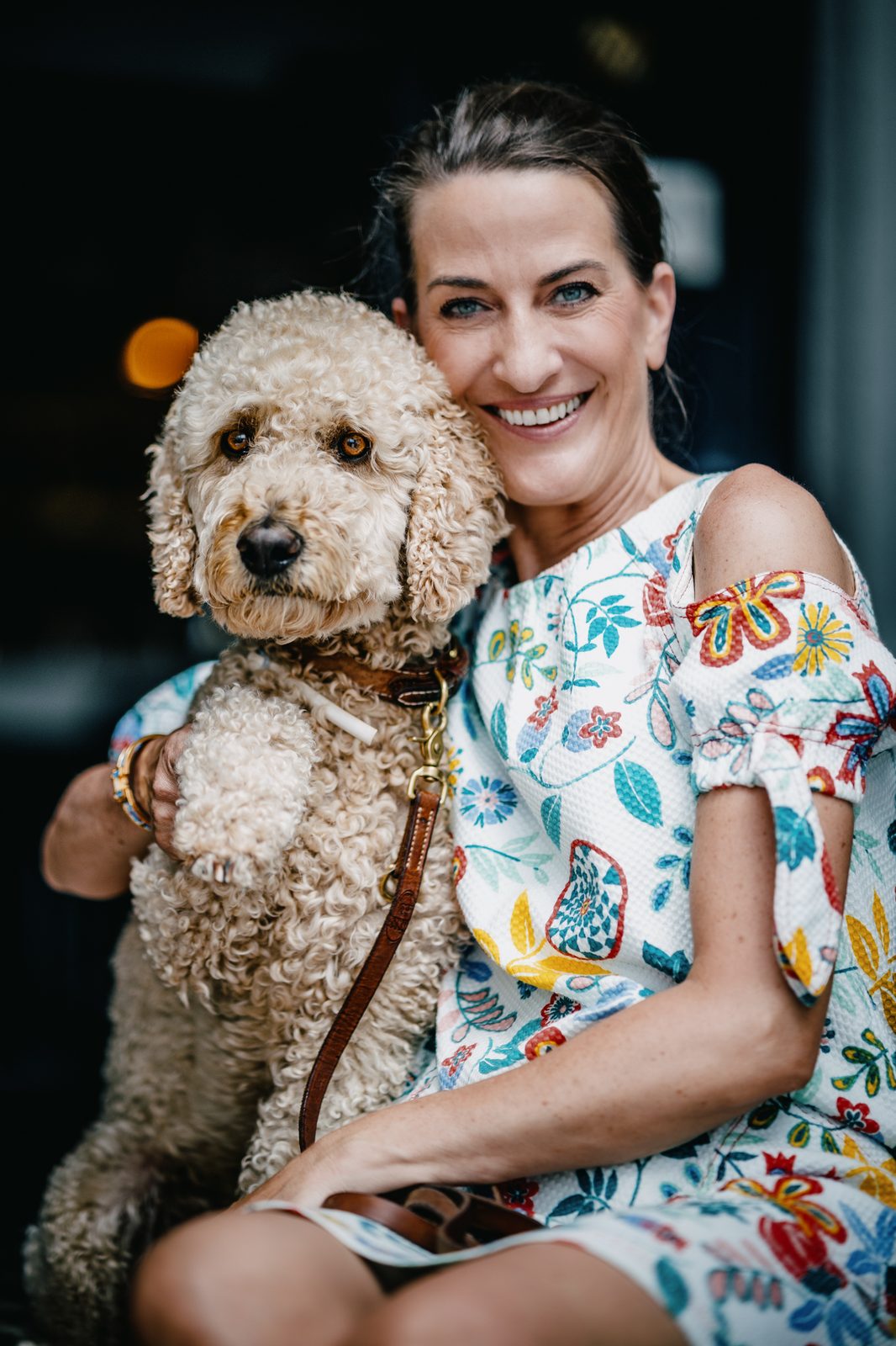 Woman holding her dog and smiling.