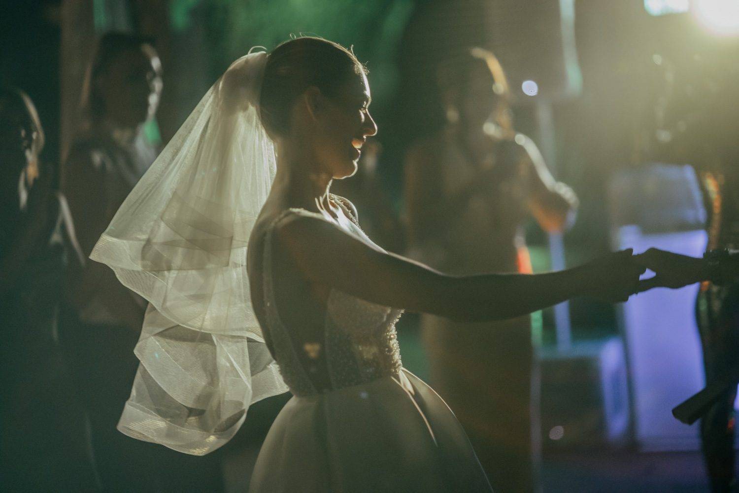 Bride moving through the evening celebration in soft light.
