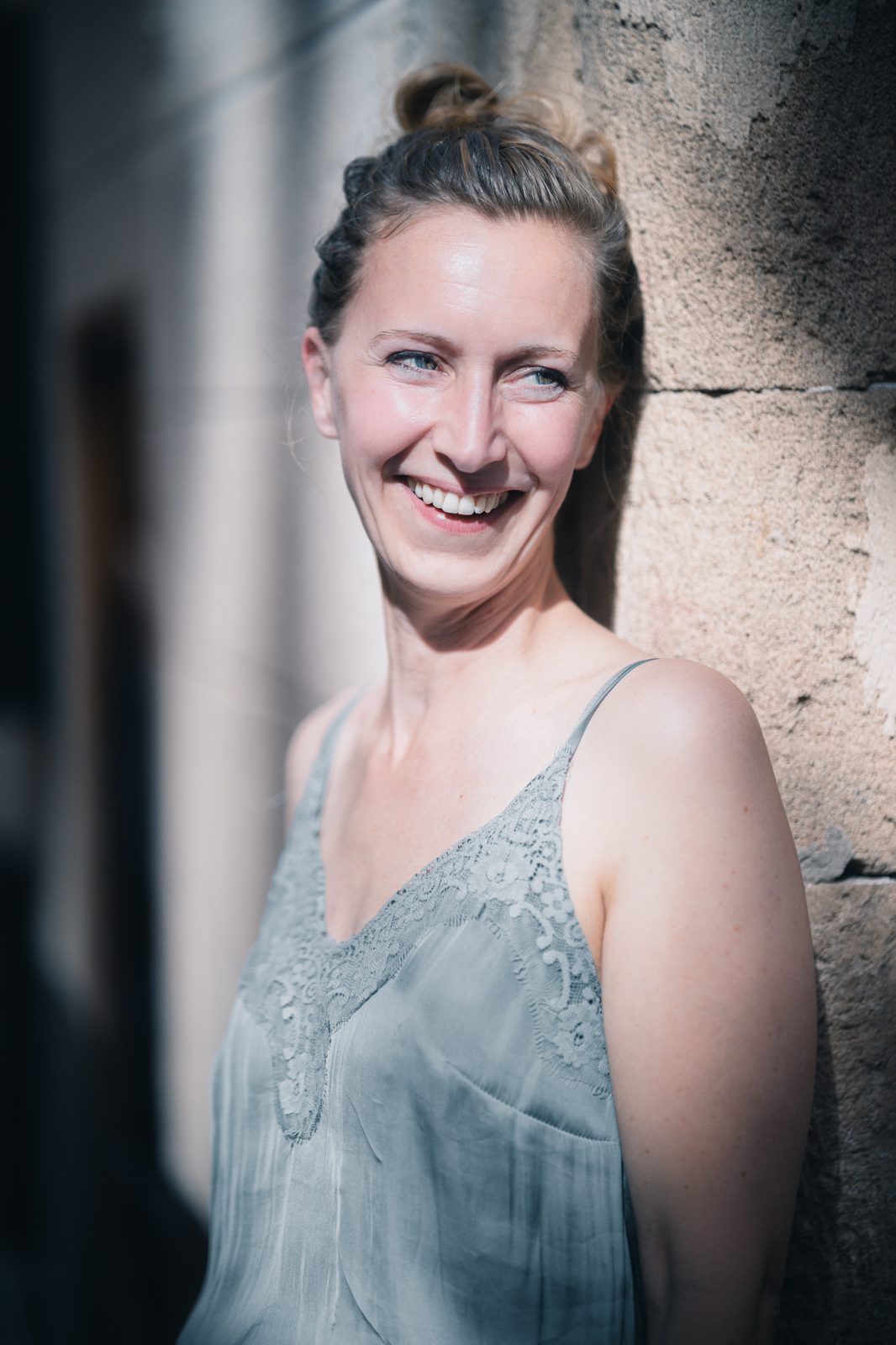 Woman smiling in bright natural light.