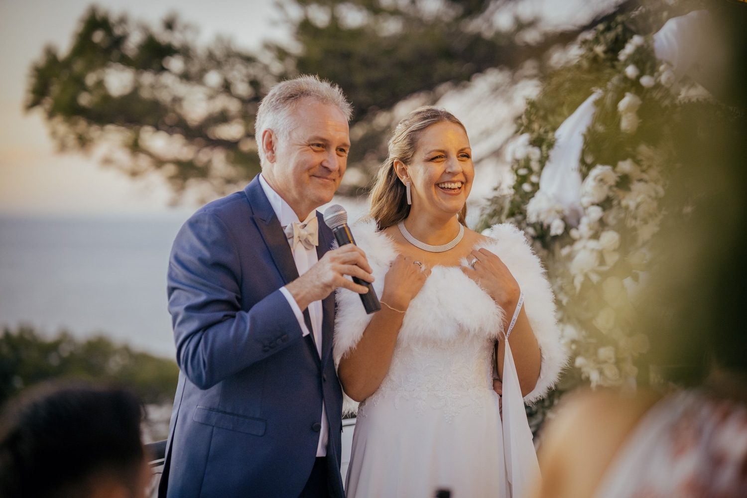 Bride standing beside her father during a speech.
