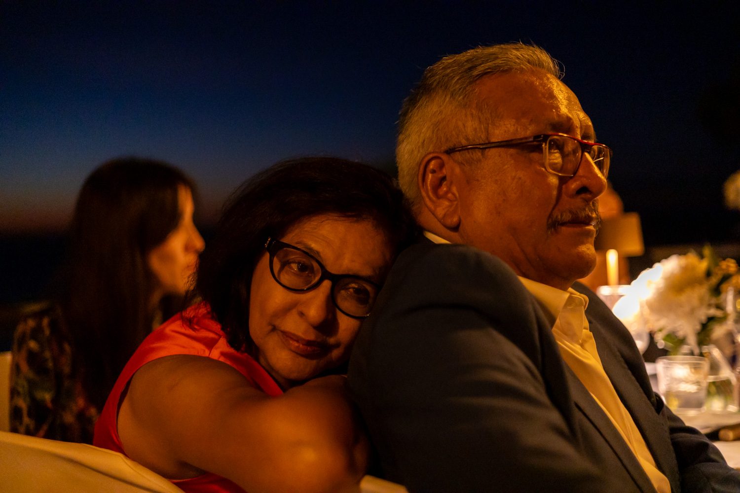Family members embracing at night during the wedding dinner.