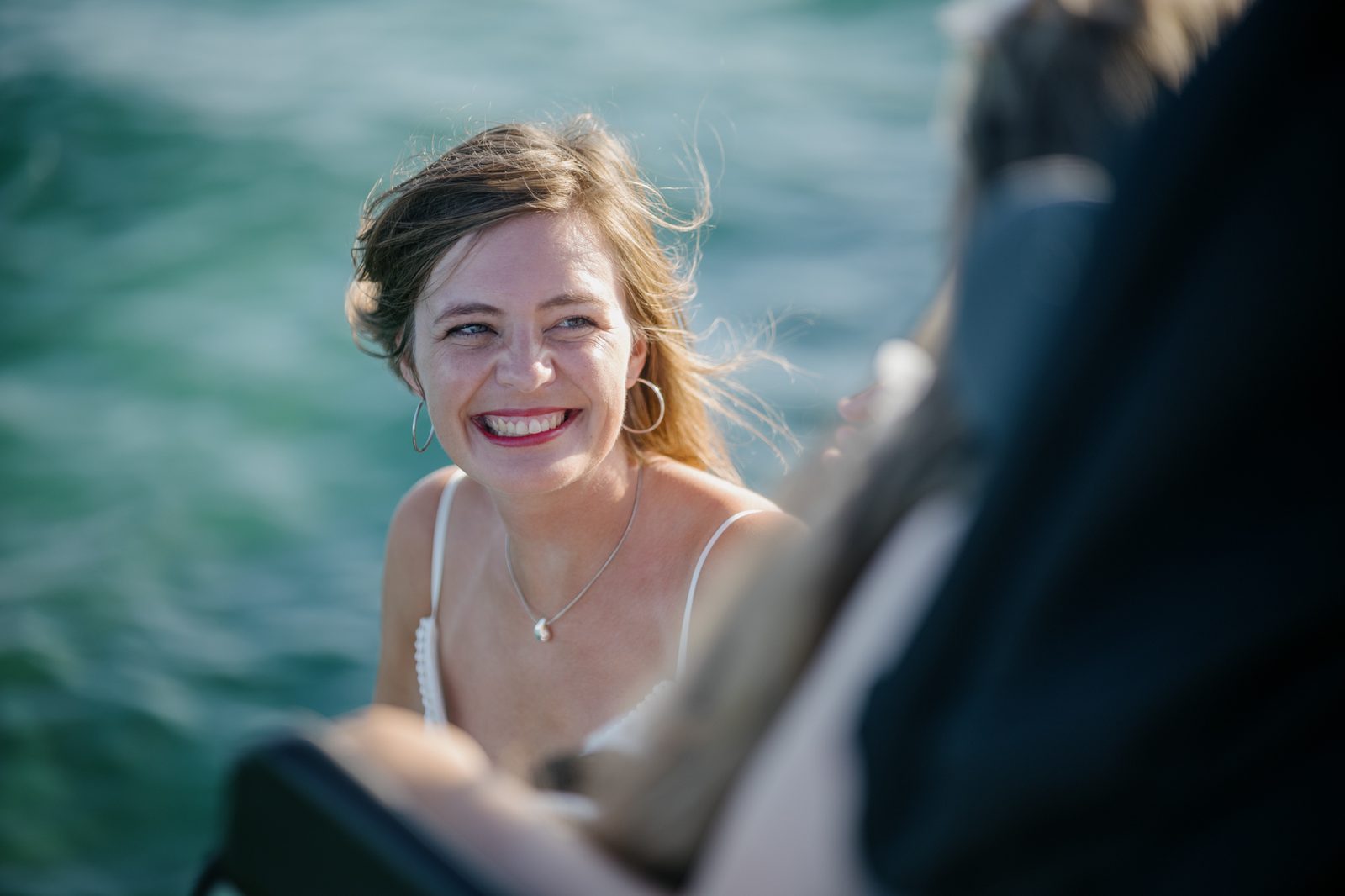 Woman smiling by the sea.