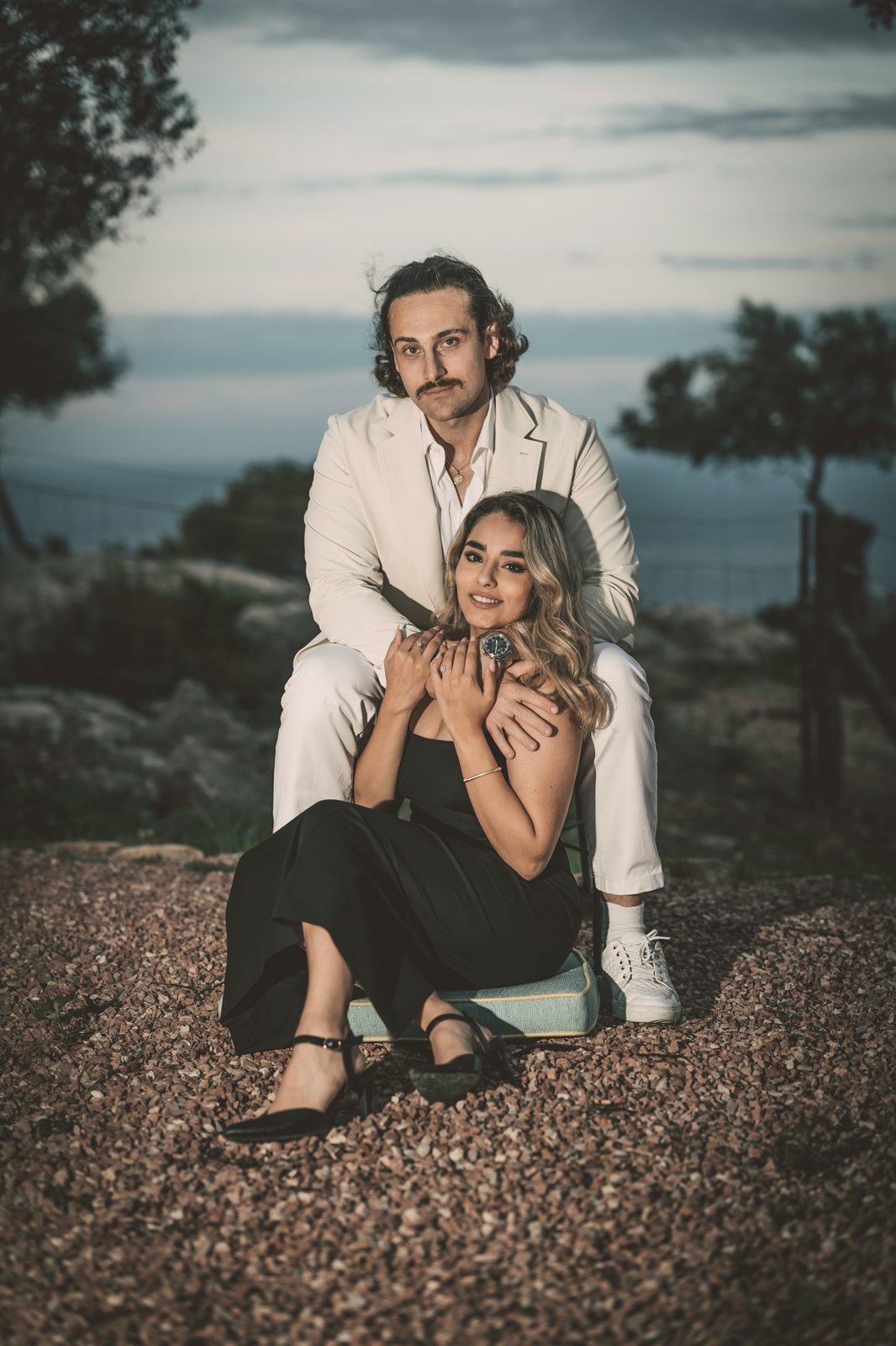 Couple posing together outdoors at dusk.