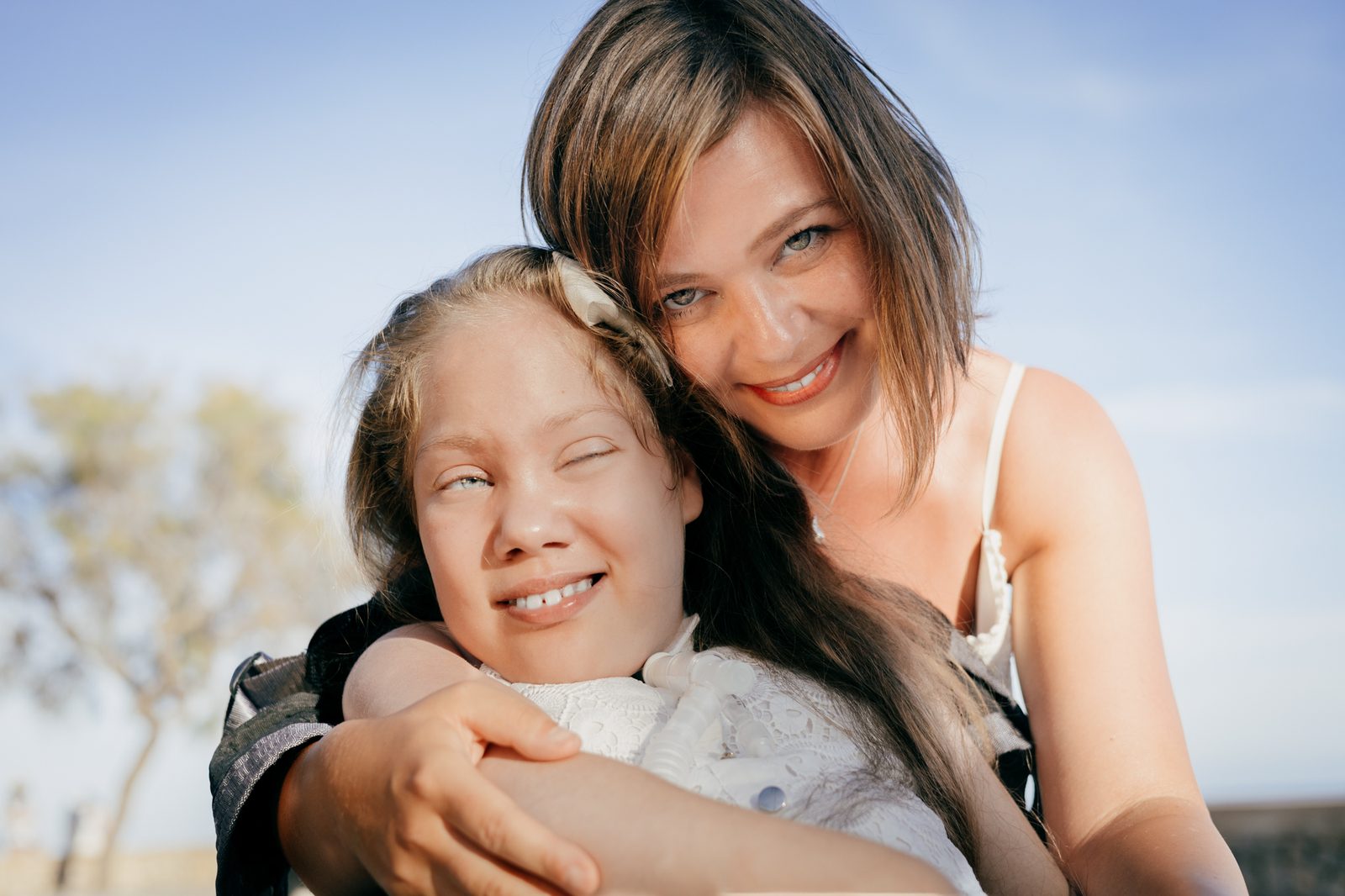 Mother and daughter embracing outdoors.