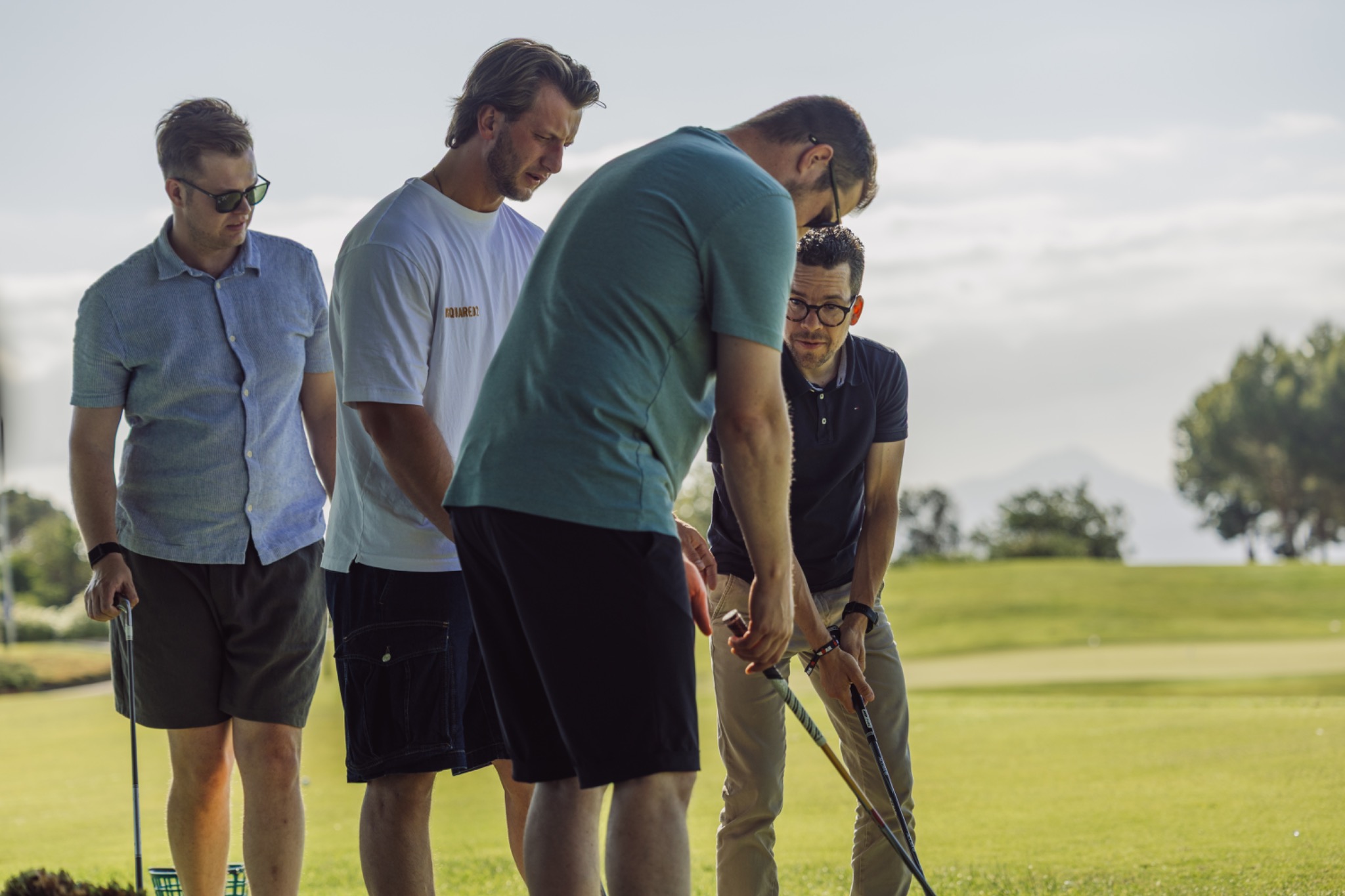 Colleagues watching and helping during a golf exercise