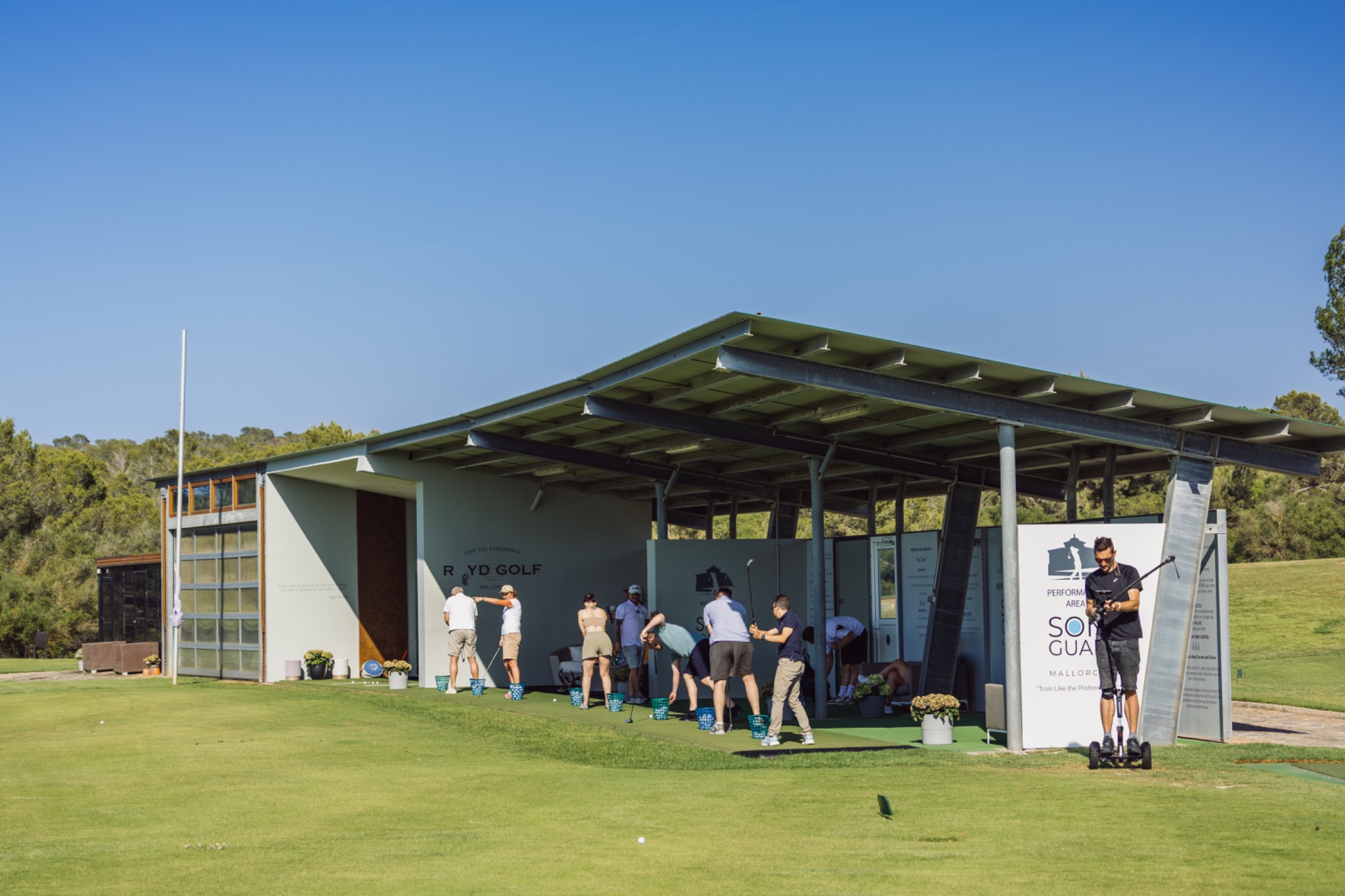 Wide view of the Artesano Group team-building activity at the golf practice area