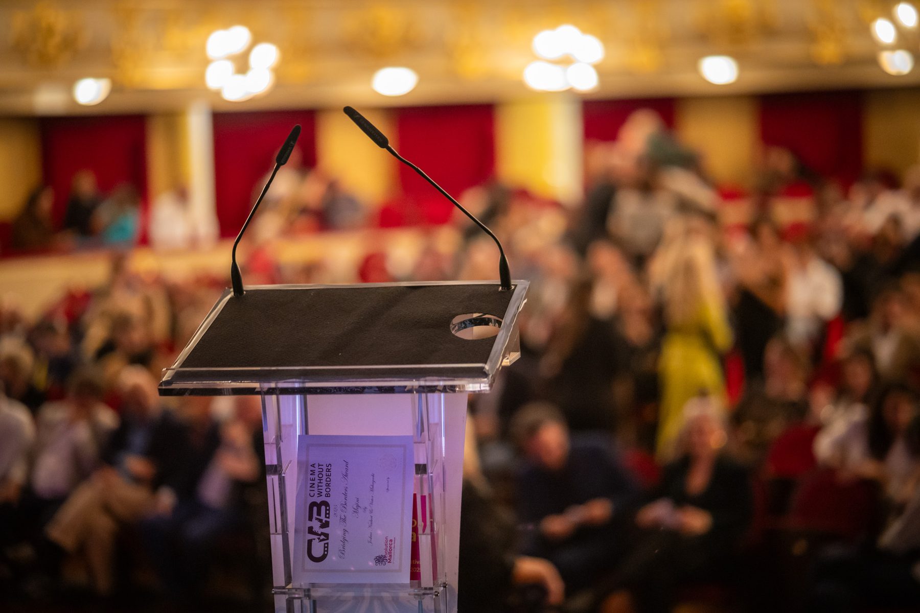 A lectern facing a seated audience in a conference setting.