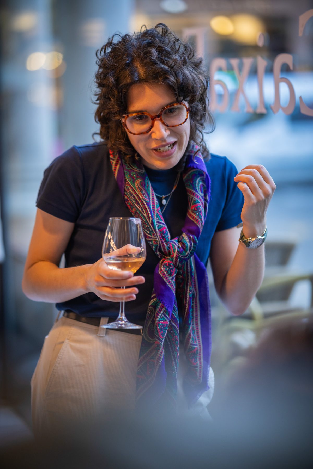 Guest laughing with a glass of wine during a reception.