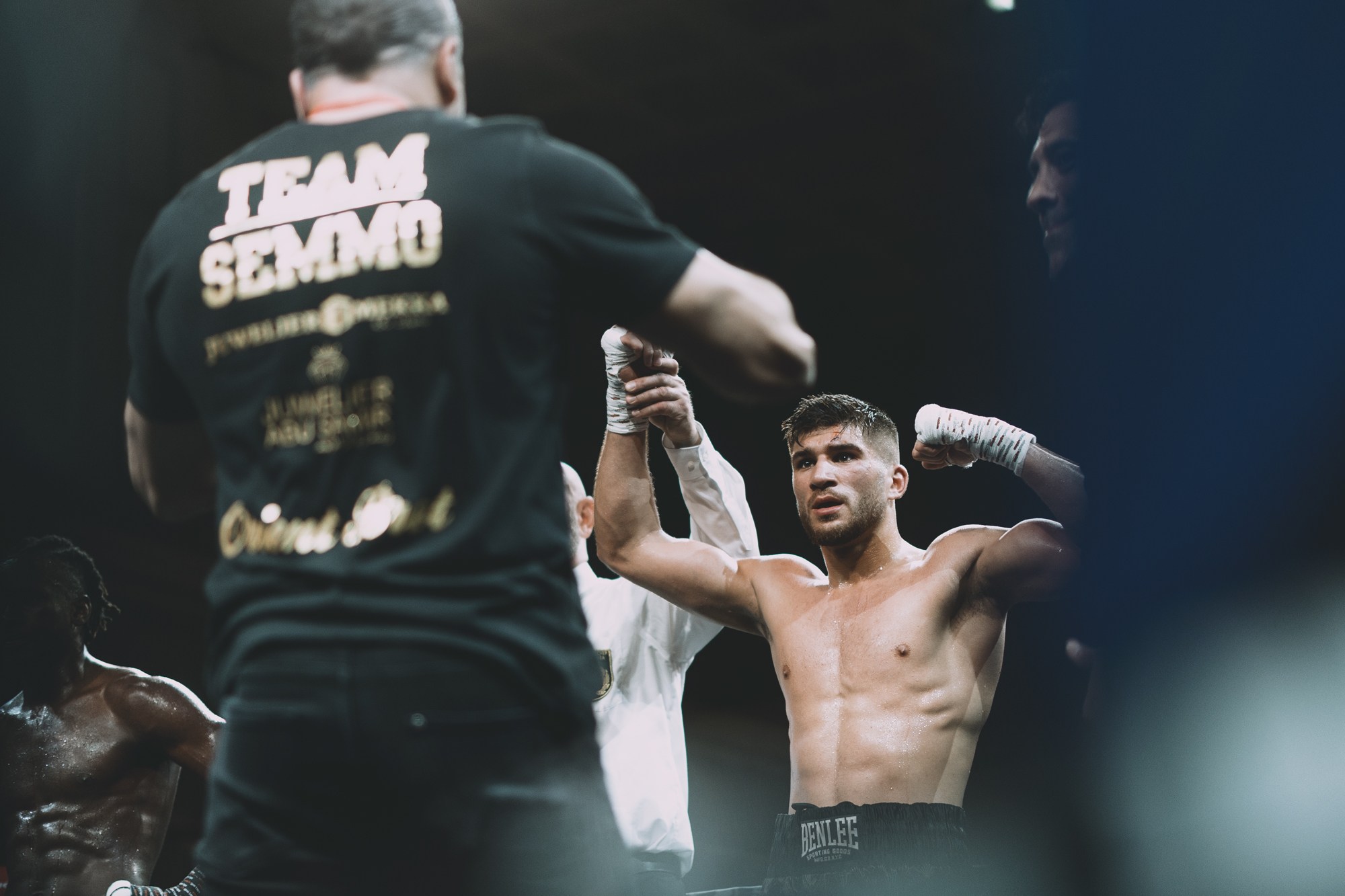 Boxer raising both arms in the ring after a fight.