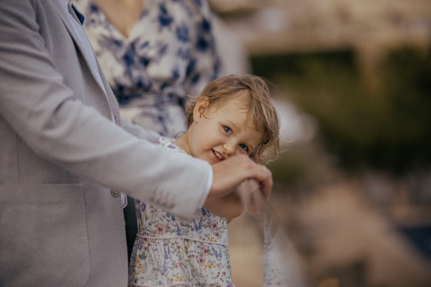 Child leaning into an adult during a wedding celebration.