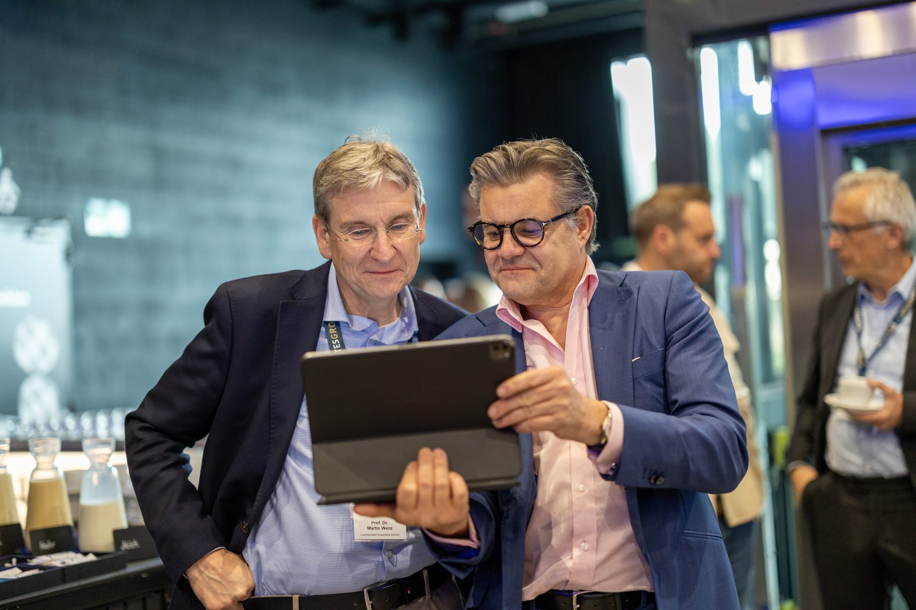 Two guests looking at a tablet during an event.