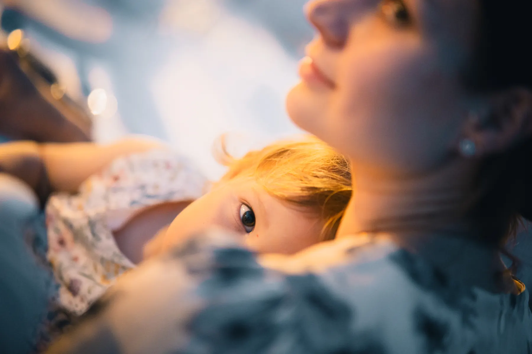 Child resting against an adult during a gathering