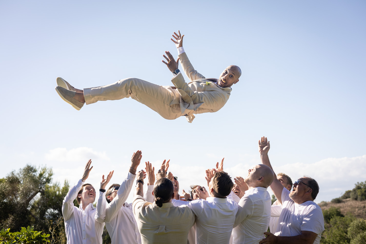 Friends lifting a guest into the air during the celebration.